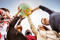 Photo of several individuals holding up a globe 